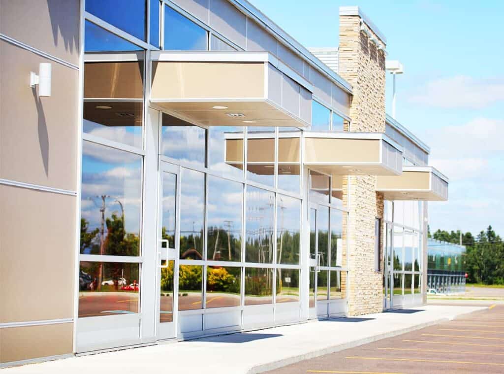 Contemporary corporate office building highlighting highly reflective architectural glass storefront windows