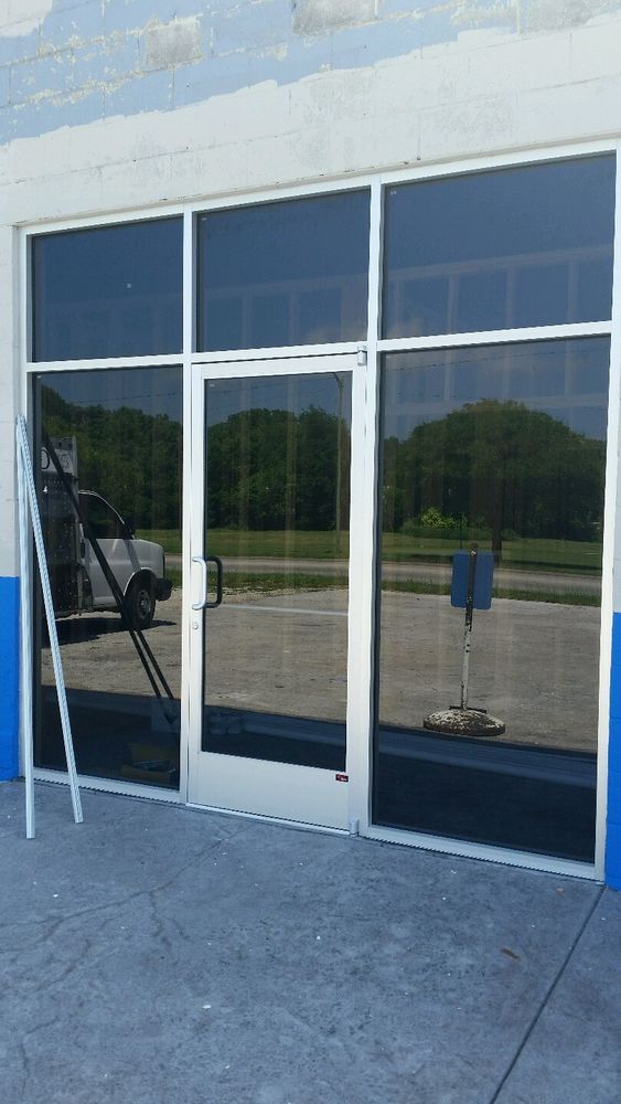 Aluminum frame commercial entryway door with dark tinted security glazing and street reflection